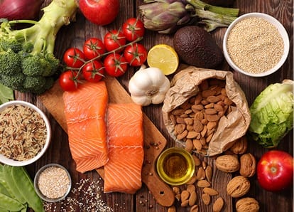 A table of raw foods featuring salmon and almonds