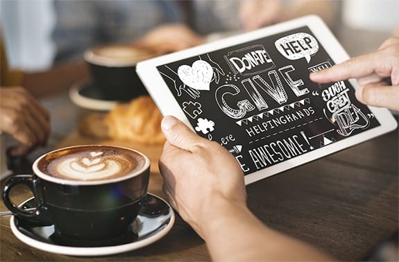 A man holds a tablet with donation words on it