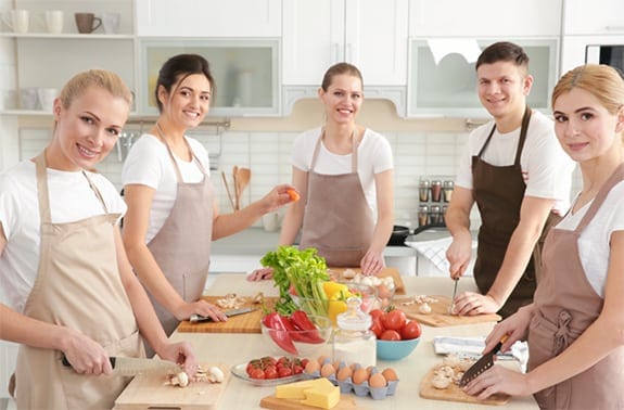 A group of chefs preparing a dinner in a kitchen